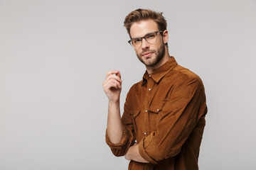 Wall Mural - Portrait of unshaven young man posing and looking at camera