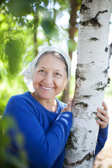 Wall Mural - elderly woman in   white scarf against  nature.