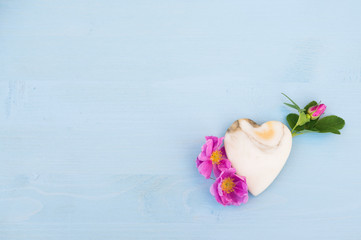 Marble Heart with roses on a blue wooden table. Valentine floral background. Copy space