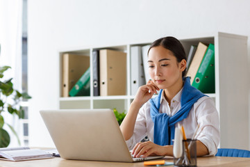 Wall Mural - Image of young asian woman using laptop computer while working in office