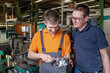 © Ingo Bartussek - A trainee in the metalworking industry and the instructor check a workpiece using a caliper