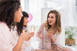 © LIGHTFIELD STUDIOS - emotional multicultural girlfriends with glasses of champagne talking on pajama party