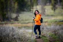 Self Care Exercise Outdoors Young Brunette Beautiful Attractive Woman Hiking In Parka With Walking Sticks Near Forest In Wilderness While Camping