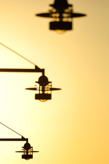 Low angle view of street lights silhouetted against sunlight, Gothenburg, Sweden, Europe