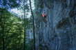 Powerful sports climber going up on an overhanging rock wall