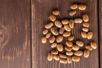 Poster - Lot of whole mottled brown bean pinto flatlay on brown wood