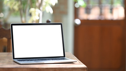 photo of computer laptop with white blank screen putting outdoors on the modern table with classic c