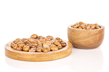 Wall Mural - Lot of whole mottled brown bean pinto on round bamboo coaster in bamboo bowl isolated on white background