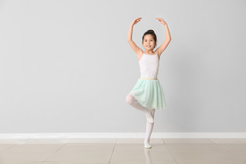 cute little ballerina against light wall