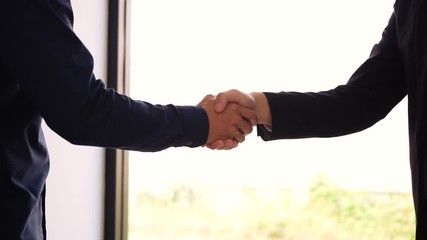 Wall Mural - Two businessmen entrepreneurs or job interviews go well and shaking hands with confidence slow motion.