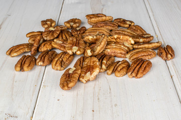 Wall Mural - Lot of whole tasty brown pecan half on white wood