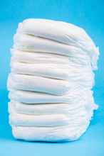 Stack Of Baby Diapers On Blue Background