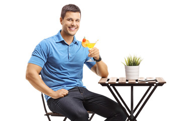 Canvas Print - Guy sitting at a table and drinking a cocktail