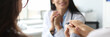 © H_Ko - Portrait of smiling doc looking at visitors with happiness. Couple holding hands and listening gynecologist carefully. Family planning specialist reporting good news to marriage