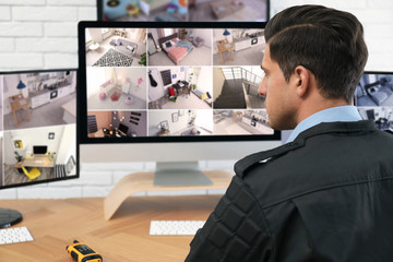 Male security guard monitoring cameras at workplace