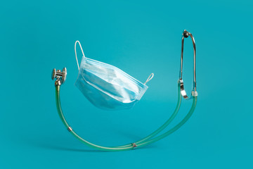 Medical blue mask against a virus, stethoscope on a blue background.