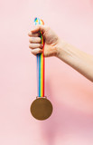Medal with colorful ribbon hung in hand