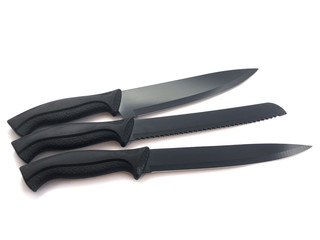 Composition of black knives isolated on white background. Composition of the chef knife, bread knife, carving knife, utility knife. Professional Set. Sharp blade. 