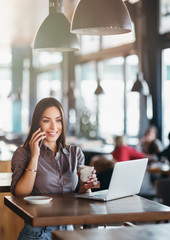 Beautiful business woman using laptop at cafe, working, having fun, enjoying.  Lifestyle concept.