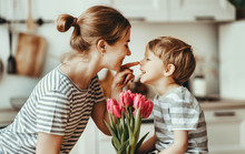Happy Mother's Day! Child Son Gives Flowers For  Mother On Holiday .