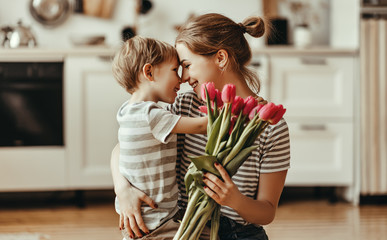 happy mother's day! child son gives flowers for  mother on holiday .