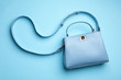 Stylish woman's bag on light blue background, top view