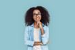 © Viktoriia - Freestyle. African girl in glasses standing isolated on gray touching chin looking up playful