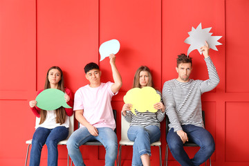 Wall Mural - Group of young people with blank speech bubbles on color background