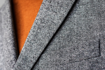 Wall Mural - Close up of mens grey wool blazer combined with brown fashionable sweater.  Low DOF. Selective focus.