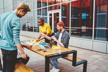 Poster - Positive guy analyzing project with coworkers in street