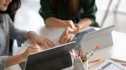 Wall Mural - cropped shot of application developer team drawing on their ui project in co working space