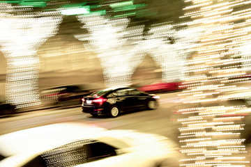 Fast car driving past tree lights