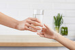 © wertinio - woman's hand gives a glass of purified water to her child. Concept purification of water