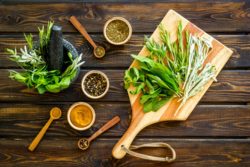 Wall Mural - Herbs and spices on dark wooden kitchen desk top-down