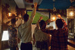 © Studio Romantic - A group of friends watching tv football in a sports bar.