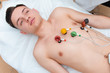 © salomonus_ - Cardiogram of the heart. A young man on a couch with attached electrodes of an electrocardiograph on his chest. Cardiology