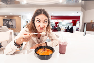 a disgruntled fast food restaurant customer sniffs spoiled food. Concept of health and expired products