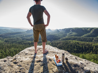 Resting man stay without shoes on view point. Tourist brink