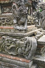 Carved Stone Gargoyle Sits Above An Elephant Carving With Upturned Trunk And Multiple Tusks At A Hindu Temple In Bali Indonesia