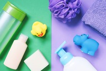 Flat Lay Photo Shampoo, Liquid Soap, Purple Towel, Sponge And Rubber Toys. Baby Care Cosmetic Products