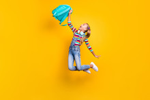 Full Size Photo Crazy Energetic Kid Jump Hold Blue Bag Rucksack Enjoy Primary School Lessons Wear Striped Sweater Jumper Denim Jeans Sneakers Isolated Bright Shine Yellow Color Background
