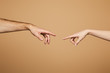 © LIGHTFIELD STUDIOS - cropped view of man and woman reaching each other with fingers isolated on beige