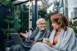 © bnenin - Successful senior businesswoman talking to a mature woman while sitting on the terrace of the modern home.