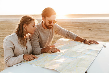 Attractive young couple looking at the travel map