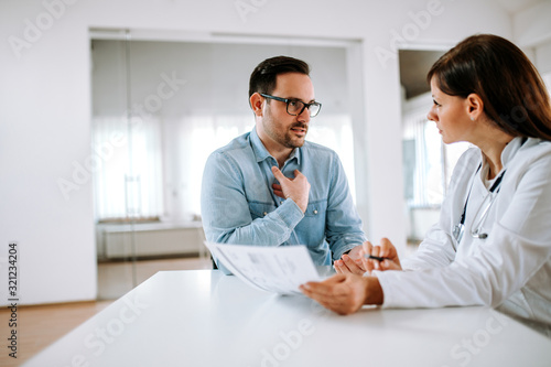 Fotomural Handsome male patient talking to a female doctor, portrait.