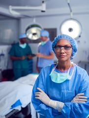 Wall Mural - Portrait Of Female Surgeon Wearing Scrubs And Protective Glasses In Hospital Operating Theater