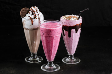 Set of different coffee drinks in glasses on black background