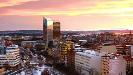 Wall Mural - Oslo, Norway. A night view of Sentrum area of Oslo, Norway, with modern and historical buildings and car traffic. Sunset colorful sky in winter with snow