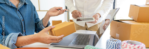 Fotomural Startup small business entrepreneur SME, young asian man working with laptop computer and delivery packaging box, online market packing, SME e-commerce seller concept