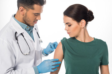 Wall Mural - Handsome doctor doing vaccine injection to female patient isolated on white